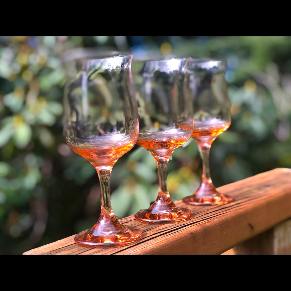 Three pink glass wine stems